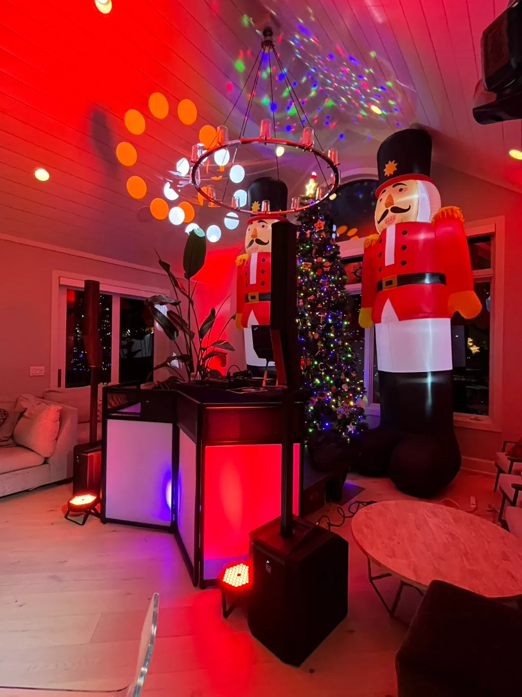 Turning a living room into a premium event space. Vibrant red uplighting and professional audio gear ready to go right alongside the nutcrackers and the tree.
